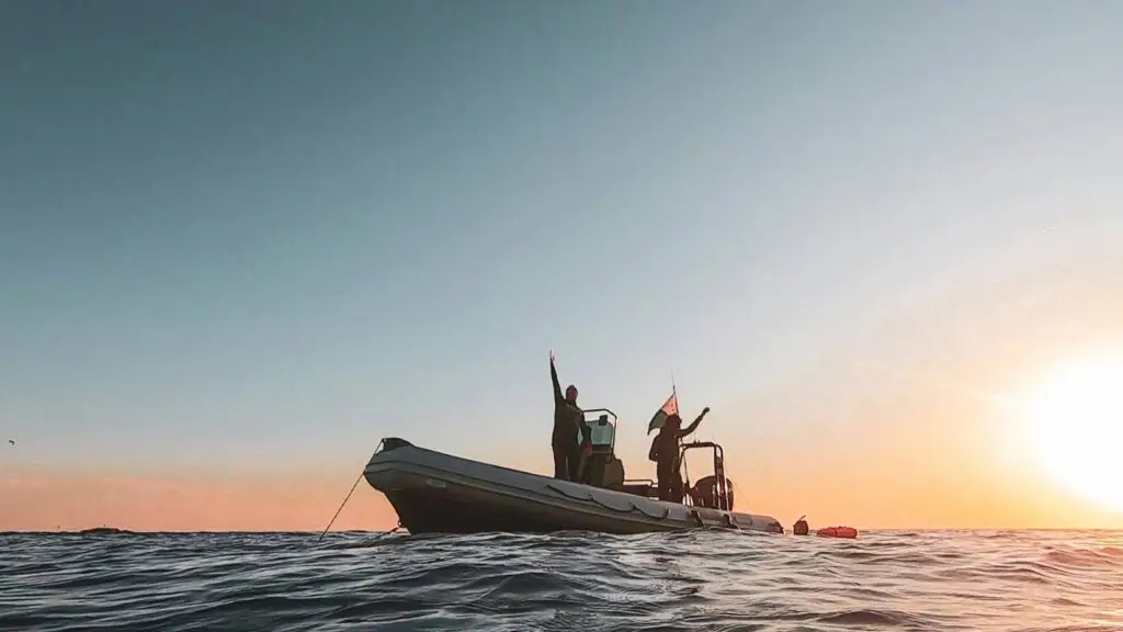 Membres du club sur le bateau semi-rigide du club au coucher du soleil, lors d'une sortie en mer